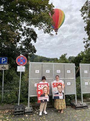 Die beiden Ortsvereinsvorsitzenden Isabell Heep und Anja Ludwig plakatieren mit besonderem Hintergrund