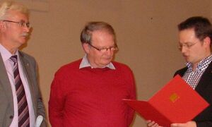 Tobias Eckert (re) überreicht als Dank und Anerkennung eine Urkunde an Heinz-Ulrich Mengel. Links: Helmut Jung